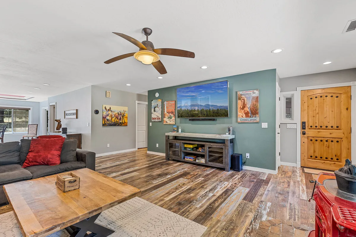 A comfortable entertainment area with a plush sofa, a coffee table, a large TV mounted on the wall, and inviting decor. The room exudes a sense of warmth, making it perfect for settling in for a movie night or simply relaxing after an active day.